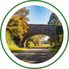 A large brick bridge extends over a country road.